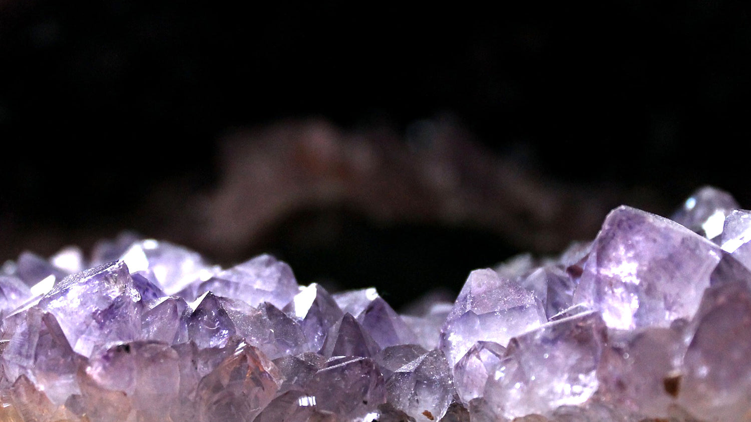 Beautiful zoom in to an Amethyst cluster with a black background